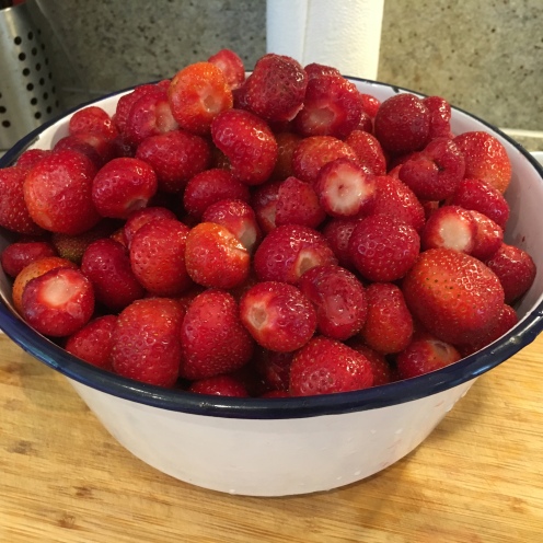 Emaille-Seihe gefüllt mit geputzten Erdbeeren